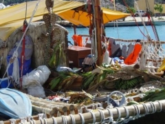Replika av polynesisk katamaran med husdyr og planter, frukt og fisk til tørk